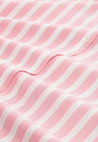 Pink and white striped fabric with a smooth texture. Features soft cotton material, visible stitching, and a small button detail.