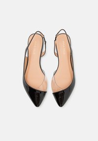 Tocuri slingback negre din piele lacuită, cu vârful ascuțit și panouri laterale transparente. Tălpi interioare bej deschis cu numele brandului embossat.