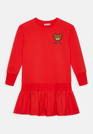 Abito rosso a maniche lunghe con orlo a sbuffo. Presenta una grafica di un orso e il testo "Moschino" ricamato in nero sul petto.