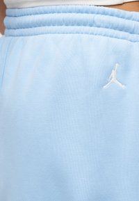 Φόρμες με ελαστική μέση σε ανοιχτό μπλε χρώμα και λευκό λογότυπο Jumpman στο πάνω μέρος του μηρού.