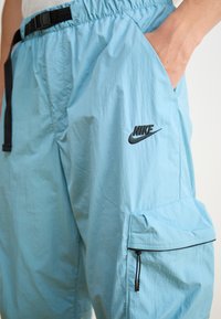 Nike Sportswear TECH WOVEN - Cargo trousers - denim turquoise/black