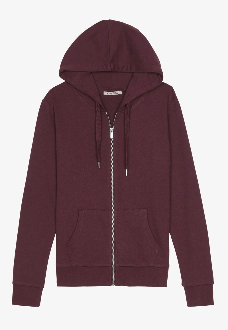 Sweat à capuche bordeaux zippé avec cordon, poches avant et manches longues, posé à plat sur fond blanc.