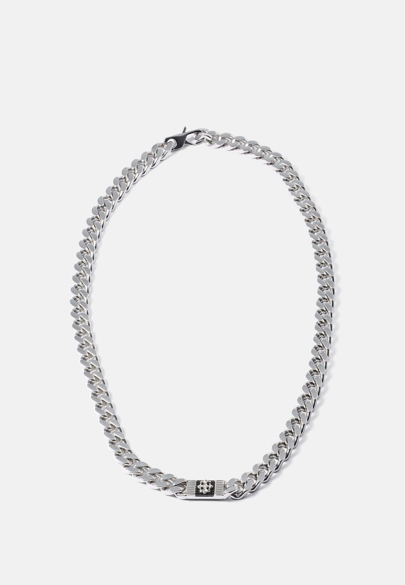 Silver curb chain necklace with a rectangular black and silver decorative clasp on a white background.