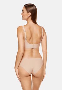 Komplet bielizny w kolorze cielistym, bezszwowy design z regulowanymi ramiączkami, miękka tekstura i gładkie wykończenie. Zapięcie na haftkę z tyłu stanika.