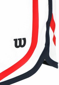 Weiße Sportshorts mit roten Akzenten und einem marineblauen Saum. Besitzen ein schwarzes "W"-Logo an der Seite. Glattes Gewebe mit leicht glänzender Textur.