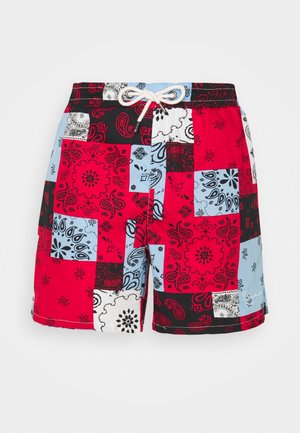 Bañador multicolor con un diseño de patchwork que presenta patrones paisley en rojo, negro, azul y blanco, cintura elástica y detalle de cordón.