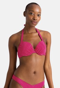 Rožinis bikini komplektas su tekstūruotu dizainu, halter tipo viršumi ir žemu juosmeniu, pabrėžiantis lygią apdailą ir ryškią spalvą.