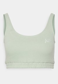 Sutiã curto em verde claro, com nervuras, alças largas e uma bainha elástica franzida. Apresenta um discreto logótipo bordado na frente. Textura suave.