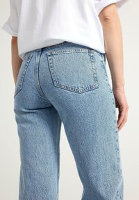 Ljusblå denimjeans med strukturerad yta, som har två bakfickor, hög midja och rak benpassform.