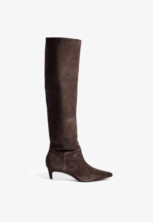 Brune ruskinds knæhøje støvler med spids tå og en lav, firkantet hæl. Designet har en glat tekstur og en tætsiddende silhuet.