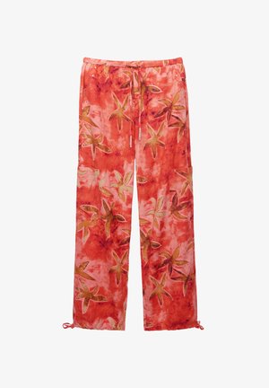 Czerwone spodnie z kwiecistym wzorem rozgwiazdy, wykonane z miękkiej tkaniny. Posiadają elastyczny pas oraz regulowane mankiety przy kostkach.