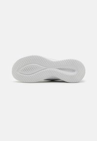 Semelle de sneaker blanche en caoutchouc texturé, présentant un motif en vagues pour l'adhérence et une section centrale lisse, conçue pour le confort et la prise.