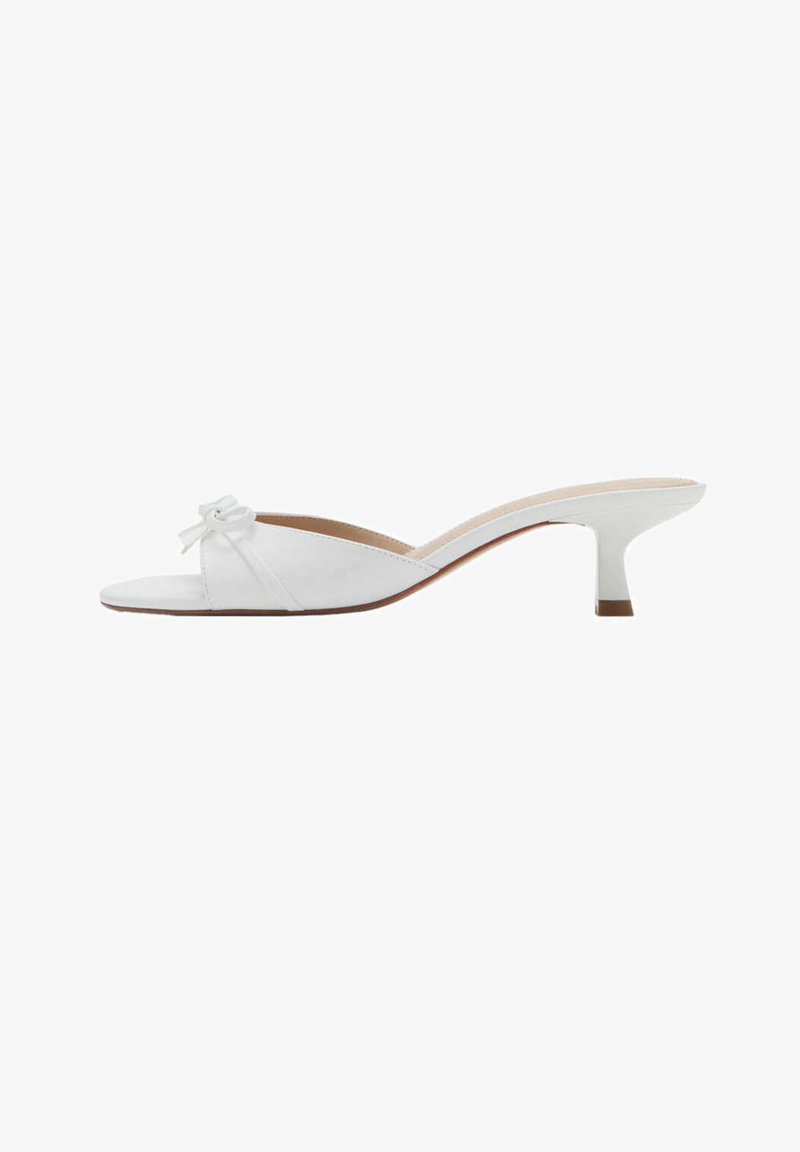 Mule en cuir blanc à bout ouvert avec un petit talon kitten et un nœud décoratif sur la bride avant.