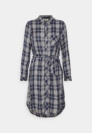 Navy blue plaid shirt dress with long sleeves, button front, chest pocket, and tie belt. Soft fabric with a curved hemline.
