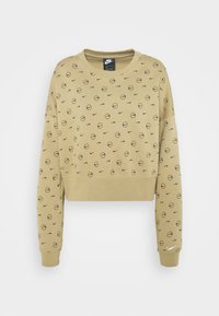 Kort sweatshirt i khaki med ett strukturerat mönster av svarta cirklar och Nike-logotyper. Ribbad halsringning och ärmslut. Mjuk tyg.
