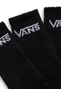 Svarta ribbade strumpor med en vit "VANS" logotyp stickad över toppen. Tillverkade av ett mjukt material med förstärkta muddar.