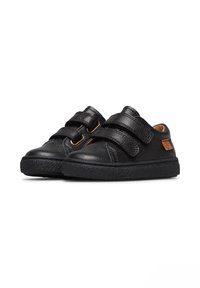 Scarpe nere in pelle con due cinturini regolabili in Velcro, finitura testurizzata, punta rotonda e una toppa con logo marrone a contrasto. Suola in gomma.