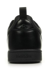 Sneaker in pelle nera con retro testurizzato e linguetta per il battito, superficie liscia e suola in gomma impreziosita dalla scritta "Redskins."