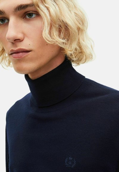 Suéter de cuello alto en azul marino, hecho de un material de punto suave, con un sutil detalle del logo en el lado izquierdo del pecho y un diseño ajustado.