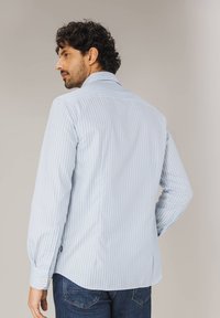 Hellblau gestreiftes Langarmshirt mit klassischem Kragen und geknöpften Manschetten, aus einem glatten Stoff mit abgerundetem Saum.