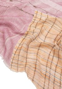 Miękka tkanina o splocie z różowym i pomarańczowym wzorem w kratkę. Tekstura z postrzępionymi krawędziami nadaje jej lekki i przewiewny charakter.