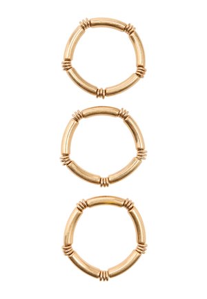 Trzy złote kolczyki-koła z rurkowymi segmentami oddzielonymi potrójnymi pierścieniami, ułożone pionowo na białym tle.