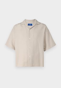 Camicia beige a maniche corte con colletto a camicia e tessuto testurizzato, esposta su uno sfondo bianco.
