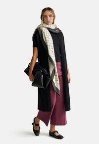 Černý dlouhý kardigan, top s krátkými rukávy, vínové široké kalhoty, vzorovaný krémový a šedý šátek, černá kožená taška, černé baleríny se páskem.