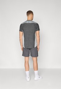 Sport t-shirt in dark gray with lighter gray accents, short sleeves, and a crew neck, paired with matching gray shorts.