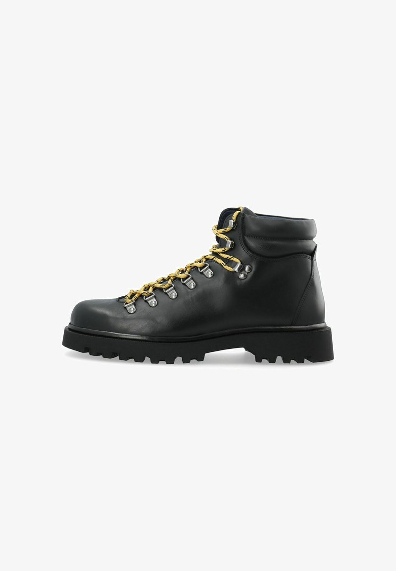 Botte de randonnée en cuir noir avec lacets jaunes, œillets métalliques, col rembourré et semelle épaisse à crampons, vue de profil sur fond blanc.