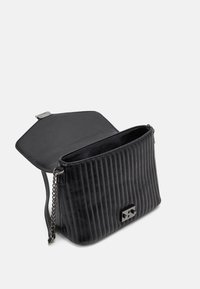 Bolso de mano de cuero negro acolchado con una superficie texturizada, correa de cadena y un cierre de solapa magnético con un pequeño acento metálico.
