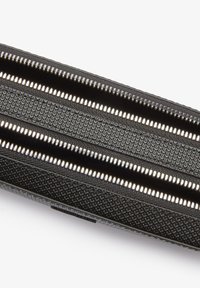 Black textured pencil case featuring three silver zippers. The exterior has a diamond pattern, providing a tactile surface.