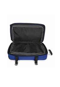 Modrá kufr s pevným povrchem, šedým zipem, černou podšívkou a popruhy pro zajištění obsahu. Obsahuje výsuvnou rukojeť.