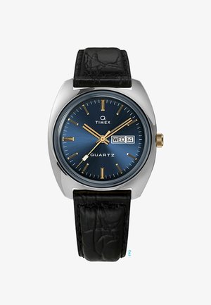 Kvarčni ura z okroglo ohišjem iz nerjavečega jekla, modrim sončnim številčnico, zlatimi oznakami za ure in črnim usnjenim pasom s krokodilskim vzorcem.