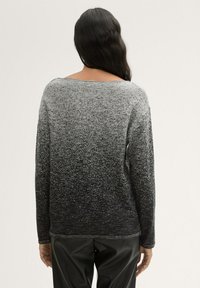 Schwarzer und grauer Gradient-Pullover mit lockerem Schnitt, langen Ärmeln, gerippten Bündchen und weitem Ausschnitt, der eine strukturierte Oberfläche zeigt.