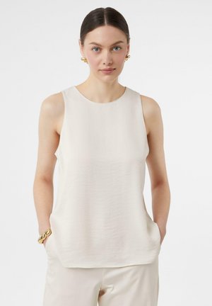 Mouwloze crèmekleurige blouse van soepel materiaal, met een ronde halslijn en zijzakken. Gestyled met een gestroomlijnd ontwerp en een natuurlijke draping.