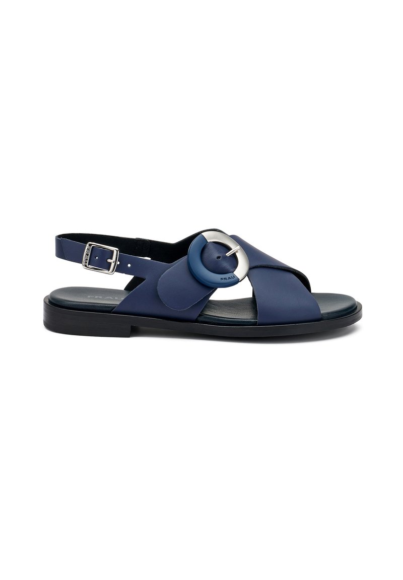 Sandal in pelle blu navy con design a strap incrociato, accento in metallo argentato circolare, cinturino alla caviglia regolabile e suola piatta.
