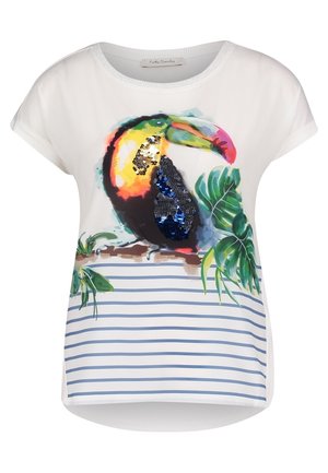 Chemise blanche à manches courtes avec des rayures bleues, ornée d'un toucan coloré avec des sequins bleus perché sur une branche avec des feuilles vertes.