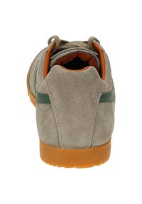 Zapatillas de ante gris con forma redondeada, que cuentan con una franja lateral verde y acentos interiores naranjas. Suela de goma con una superficie texturizada.