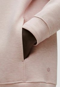 Sudadera rosa con una textura suave, que cuenta con un bolsillo lateral y un logo sutil. La manga tiene un detalle de puño acanalado, que mejora el ajuste.