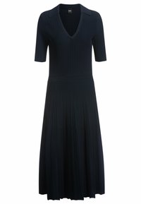 Czarna sukienka z prążkowanym wzorem, posiadająca dekold w kształcie litery V, krótkie rękawy oraz dopasowaną talię, która przechodzi w plisowany spódnicę. Klasyczny kołnierzyk.