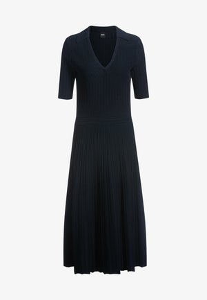 Donker geribbelde jurk met een V-hals, korte mouwen en een getailleerde taille die uitloopt in een geplooide rok. Klassiek kraagdetail.