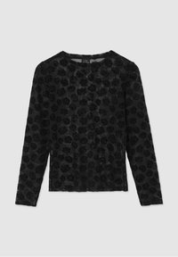 Haut noir à manches longues pour femme en tissu transparent avec motif de rose texturé, encolure ronde et ourlet droit sur un fond clair uni.
