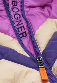 Quilted jacket with purple, pink, and cream panels. Features a contrasting zipper with an orange tag and "BOGNER" logo in black.