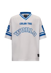Biała koszulka z niebieskim napisem "POKOLORUJ ŚWIAT", krótki rękaw, dekolt w serek oraz numeryczne akcenty na lewym rękawie.