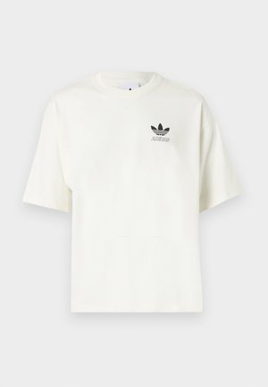 Valge lühikeste varrukatega T-särk ümara kaelusega, millel on vasakul rinnal väike must Adidas trefoil logo ja tekst.