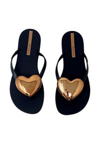 Infradito neri con una soletta texture, dotati di brillanti accenti a forma di cuore dorati sulla cinghia del piede. Logo del marchio visibile sulla soletta.