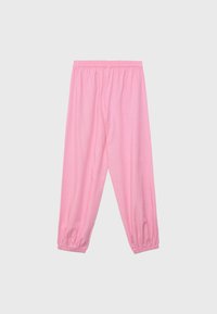 Pantalon rose ample avec taille élastique et poignets élastiques sur un fond uni clair.