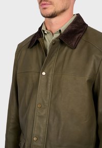 Olive green leather jacket with a brown corduroy collar, featuring gold snap buttons and a smooth texture, tailored for a fitted look.
