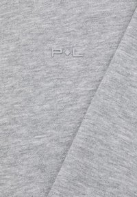 Jasnoszara tkanina o gładkiej fakturze i subtelnym melanżowym wzorze; na środku znajduje się niewielkie wytłoczone logo "P.L".